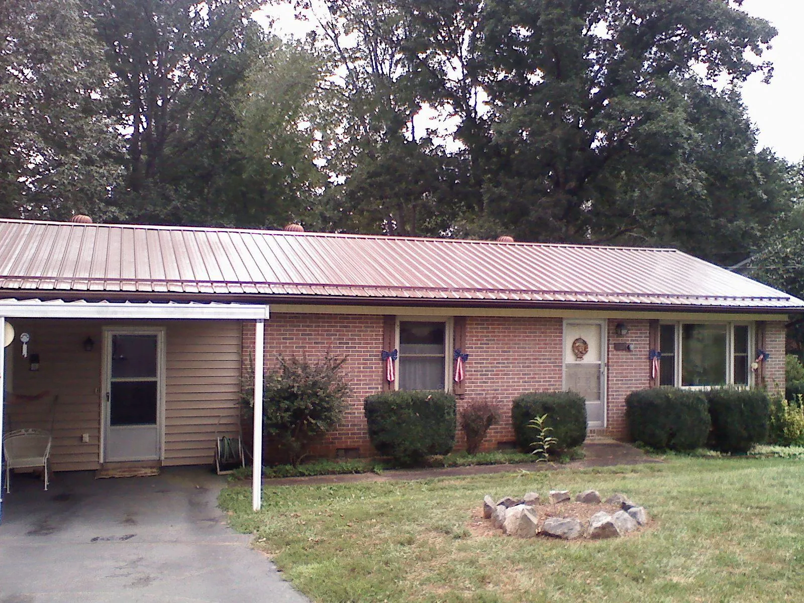 Bronze metal roof and carport on a brick ranch home — Roof Repair work by our crew in Rodeo
